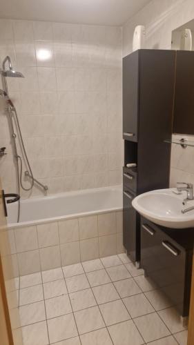 a bathroom with a sink and a bath tub and a toilet at Gemütliches Apartment in Altendorf
