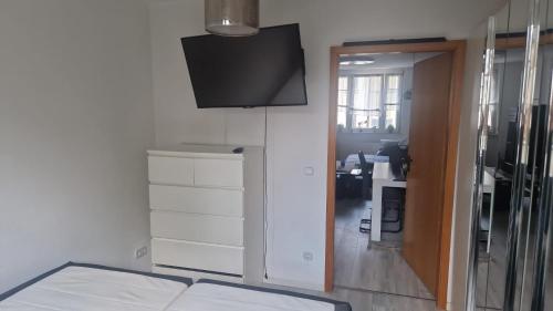 a room with a television and a room with a desk at Gemütliches Apartment in Altendorf