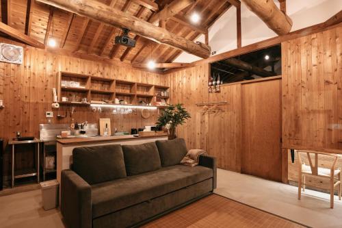 a living room with a couch and a kitchen at River & Forest Genpuan Sauna Drum bath BBQ Hearth in Shibukawa
