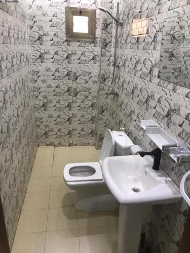 a bathroom with a white toilet and a sink at Hotel Residence Ami Bamba in Sali Nianiaral