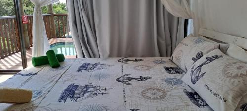 a bed with a green toy on top of it at Baleia Azul - House 7A in Ponta Mamoli
