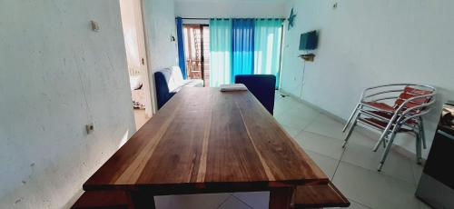 a long wooden table in a room with a chair at Baleia Azul - House 7A in Ponta Mamoli