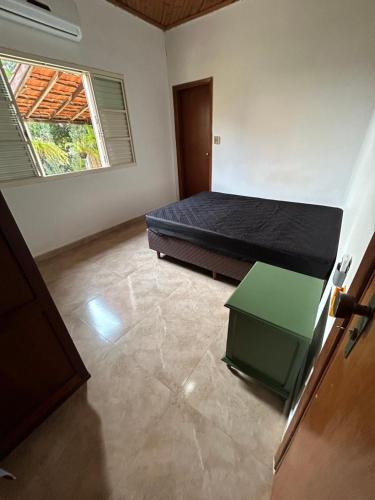 a bedroom with a bed and a table in it at Recanto Manga da Rosa - casinha de fazenda no centro da cidade in Olímpia