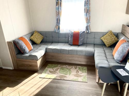 a couch in a living room with a window at No 61 Brynteg Country & Leisure Retreat in Cwm-y-glo
