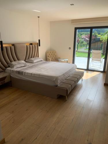 a large bed in a bedroom with a wooden floor at Maison Jacuzzi in Thonon-les-Bains