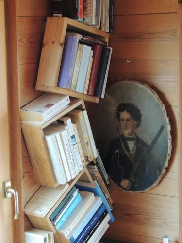 un portrait d'un homme sur un mur avec des livres dans l'établissement Ravissante maison Face mer à St Guénolé Penmarc'h, à Saint-Guénolé