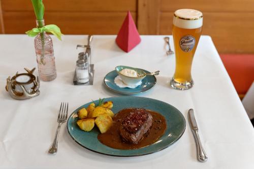 a table with a plate of food and a glass of beer at Jägerheim in Nürnberg