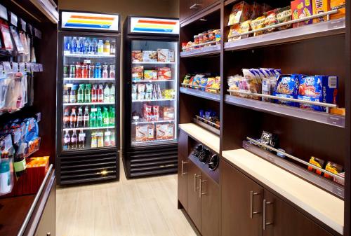 a grocery store aisle with two large refrigerators at Hawthorn Suites by Wyndham Bridgeport in Bridgeport
