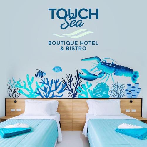 a bedroom with two beds and a sign that reads tofu sea boutique hotel and b at Touch Sea Boutique Hotel&Bistro in Karon Beach