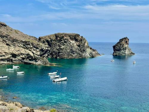 a group of boats in the water near some rocks at TramontanaBeach in Tracino