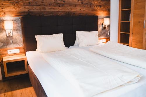 two twin beds in a room with two lamps at Hotel Rauscher - Das Naturteichparadies in Bad Hofgastein