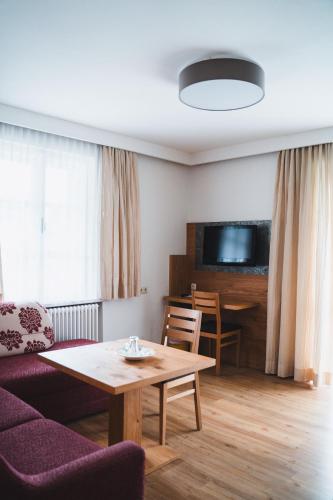 a living room with a couch and a table at Hotel Rauscher - Das Naturteichparadies in Bad Hofgastein