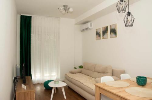 a living room with a couch and a table at M apartman Kragujevac in Kragujevac