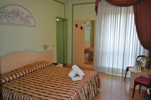 a hotel room with a bed with two pillows on it at Hotel Alsazia in Sirmione