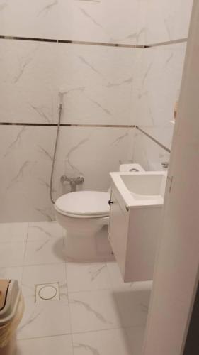 a white bathroom with a toilet and a sink at مصيف ابها in Abha