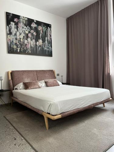 a bedroom with a large bed with a large painting on the wall at Lisetta Gardens Boutique & Suites in Cisternino