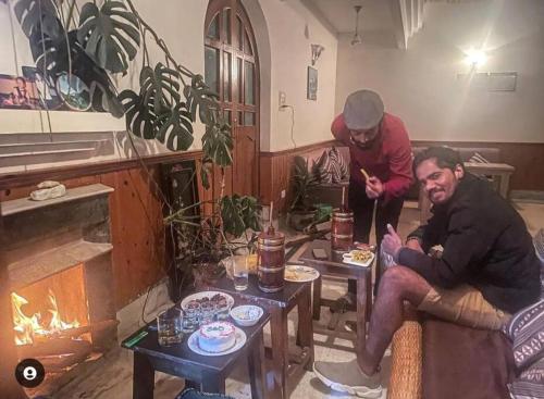 two men sitting in a living room with a fireplace at Ronglyang Lotus Villa in Tādong