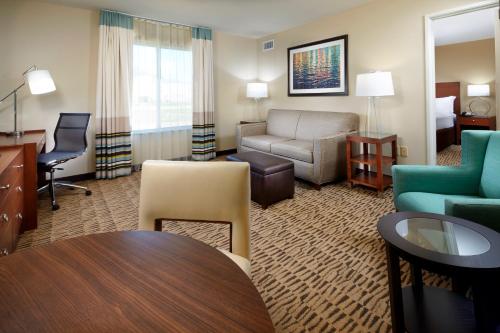 a hotel room with a couch and a table and chairs at Hawthorn Suites by Wyndham Bridgeport in Bridgeport