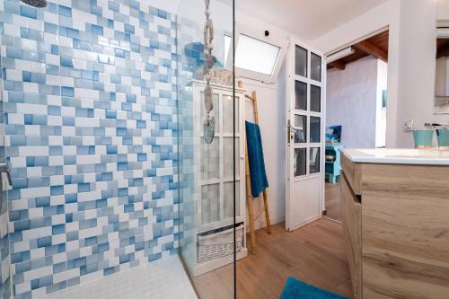 a bathroom with blue and white tiles on the wall at Casa Cueva in La Oliva