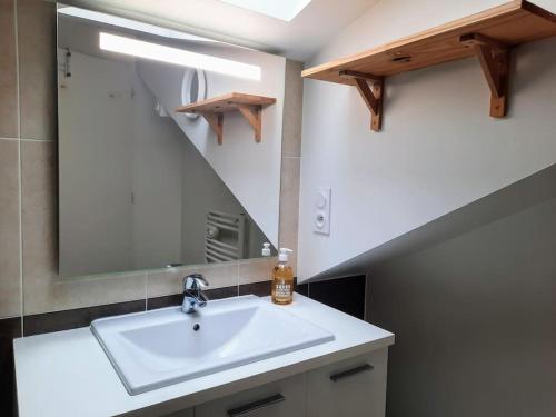 une salle de bain avec un lavabo et un miroir dans l'établissement Élégante Maison de ville, à Pornic