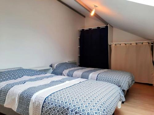 une chambre avec deux lits dans un grenier dans l'établissement Élégante Maison de ville, à Pornic