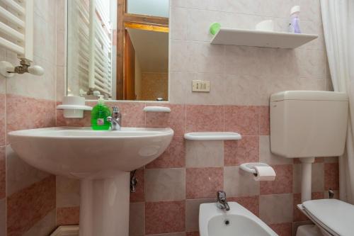 a bathroom with a sink and a toilet and a mirror at Antica Dimora Marinelli in Ficarra