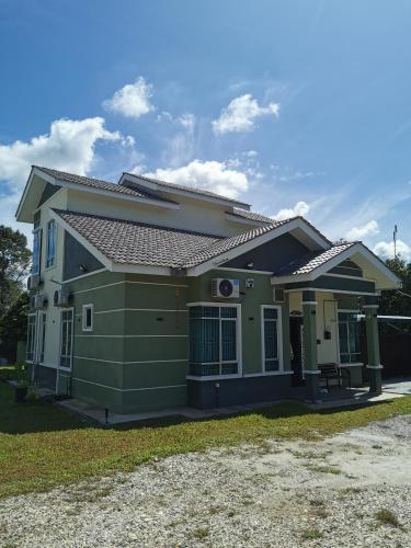 a green house with a roof at Teratak Dusun NadzYan in Bukit Selambau