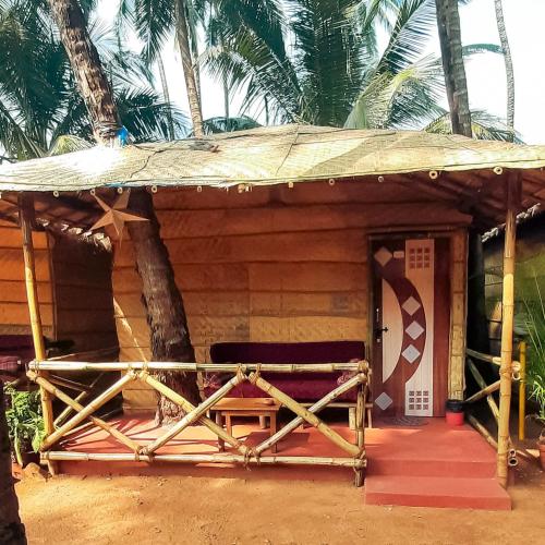 a wooden hut with a bench in front of it at Dunes Holiday Village in Mandrem