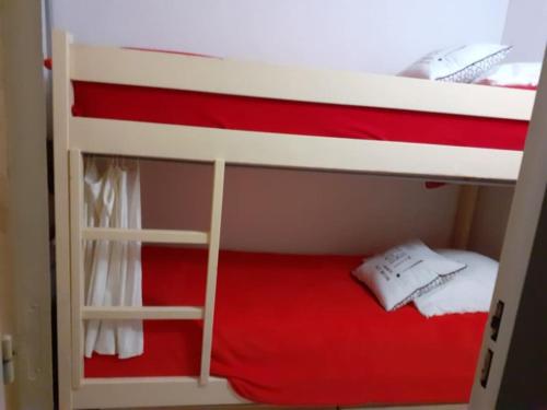 - un lit superposé avec un couvre-lit rouge et blanc dans l'établissement Castor - Studio hyper center - Ski, à Villard-de-Lans