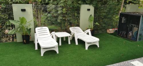 a group of white chairs sitting on the grass at Teratak Dusun NadzYan in Bukit Selambau