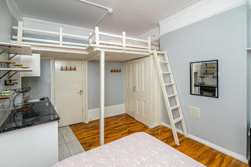ロンドンにあるPrivate Room in Quirky Sohoのロフトベッド1台とキッチンが備わる客室です。