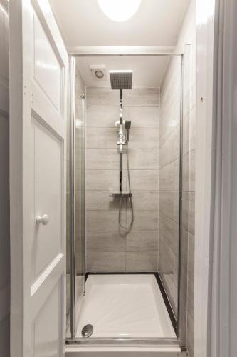 a bathroom with a shower with a glass door at Private Room in Quirky Soho in London
