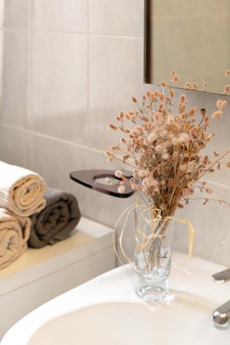 a vase of flowers sitting on a sink in a bathroom at Villa Shanti Yoga & Meditation in Marciana