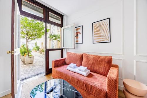 - un salon avec un canapé orange et une table en verre dans l'établissement Appart 1 chambre#Tour Eiffel#Champ de Mars#Paris 7, à Paris