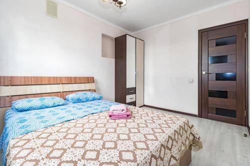 a bedroom with a bed with a pink bag on it at Уютная Евродвушка рядом с Центральной Мечетью in Pavlodar