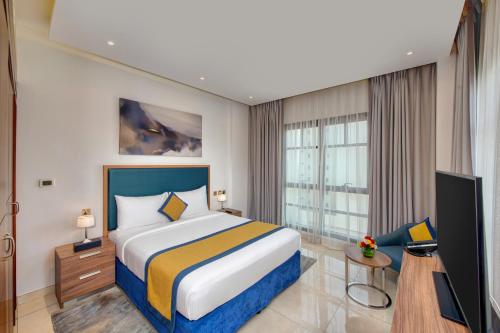une chambre d'hôtel avec un lit et une télévision dans l'établissement SUHA Creek Hotel Apartment, Waterfront Jaddaf, Dubai, à Dubaï