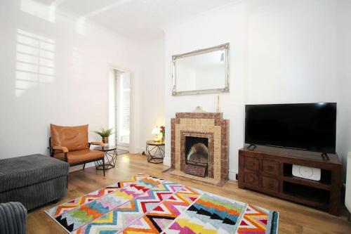 a living room with a television and a fireplace at Cottage in Walton on the Naze in Walton-on-the-Naze