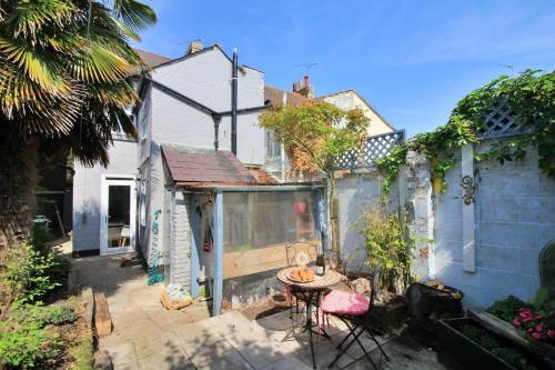 a patio with a table and chairs in a backyard at Cottage in Walton on the Naze in Walton-on-the-Naze