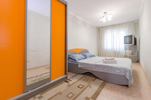 a small bedroom with a bed and a television at Три комнаты в Центре. in Pavlodar