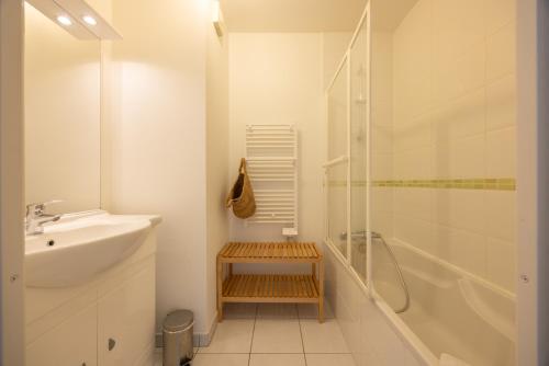 une salle de bain blanche avec un lavabo et une douche dans l'établissement Mayence Parking Cité des Congrès 4pers Tv Wifi, à Nantes