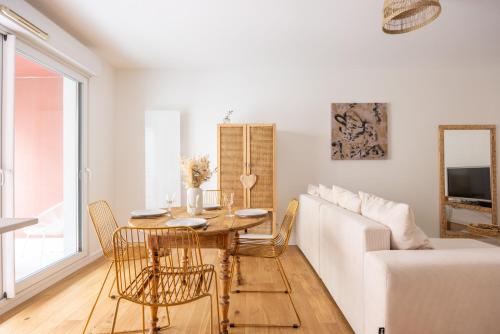 un salon avec une table et un canapé blanc dans l'établissement Mayence Parking Cité des Congrès 4pers Tv Wifi, à Nantes