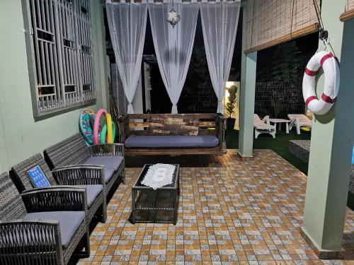 a living room with two couches and a table at Teratak Dusun NadzYan in Bukit Selambau