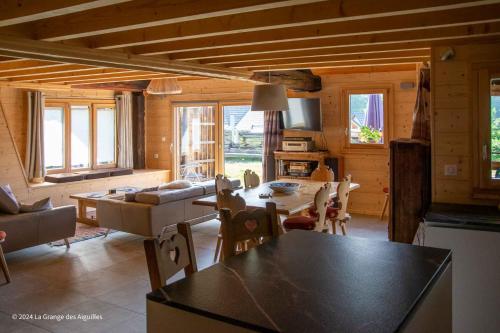 Una cocina y una sala de estar con mesa y sillas. en La Grange des Aiguilles, en Albiez-le-Jeune