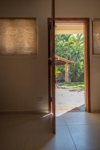 an open door to a room with a view of a yard at Espaço CurAmar - Praia de Itamambuca in Ubatuba