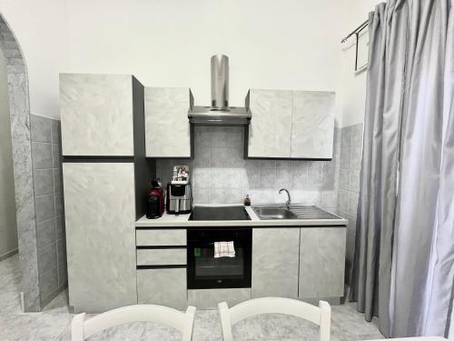 a small kitchen with a sink and a stove at L’angolo rosa in Carosino