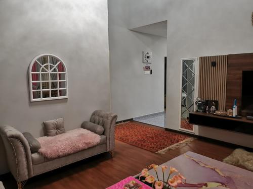 a living room with a couch and a table at Teratak Dusun NadzYan in Bukit Selambau