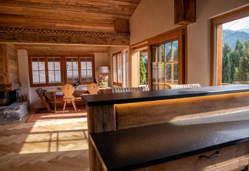 a living room with a fireplace and a large window at Modernes Chalet mit Sauna, Whirlpool und Bergblick in Sankt Stephan