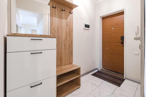 eine Küche mit weißen Schränken und einer Holztür in der Unterkunft Трехкомнатная квартира рядом с ЖД вокзалом in Pawlodar