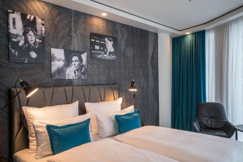 a bedroom with a bed with blue and white pillows at Motel One Berlin-Upper West in Berlin