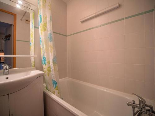 une salle de bain avec une baignoire blanche et un lavabo dans l'établissement Studio coquet à 50m des pistes, proche commerces, balcon et casier à ski - FR-1-356-204, à Valmorel